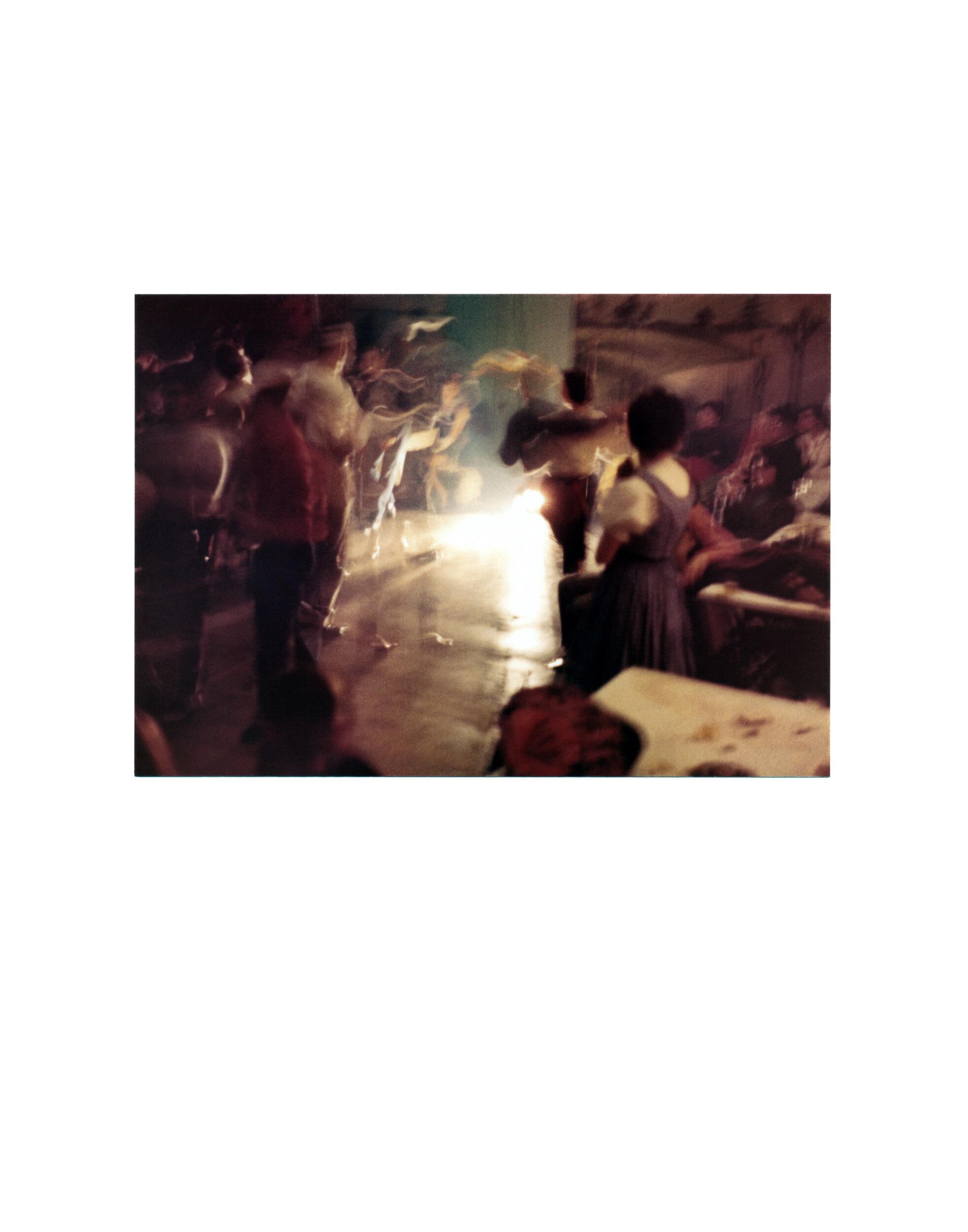 A dark blurry photo of people dancing 