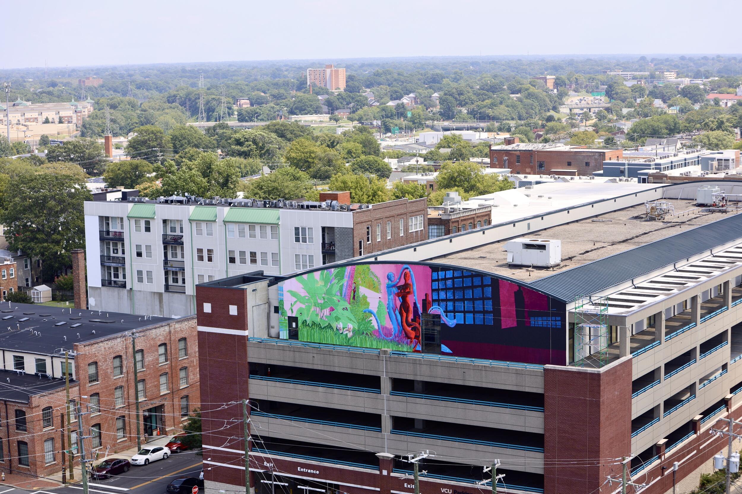 A photo of a building with a mural painted on the side. 