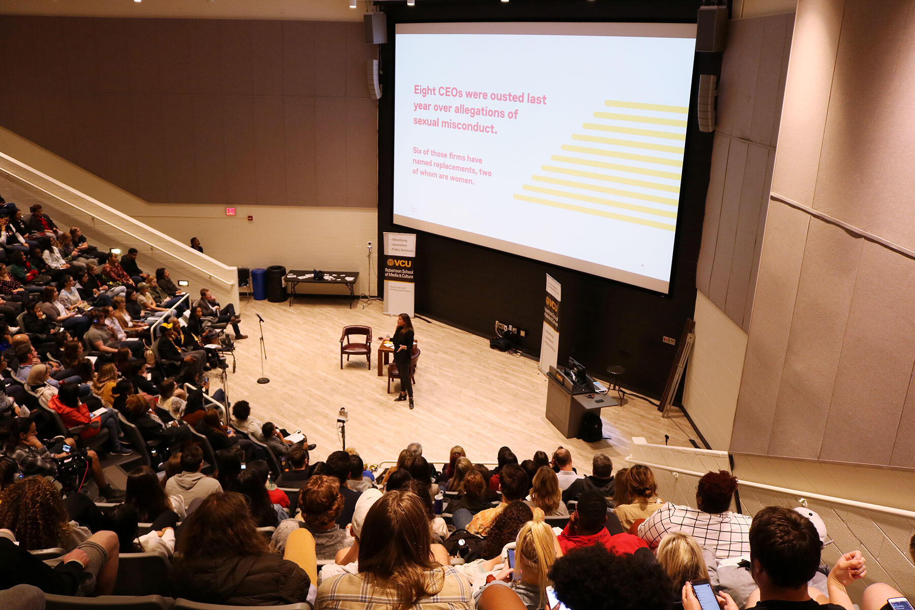 A speaker in front of a crowd of people.