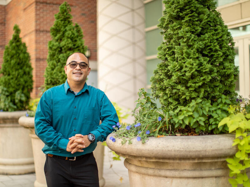 Nathan Tuoch wearing a teal blue shirt and tinted glasses