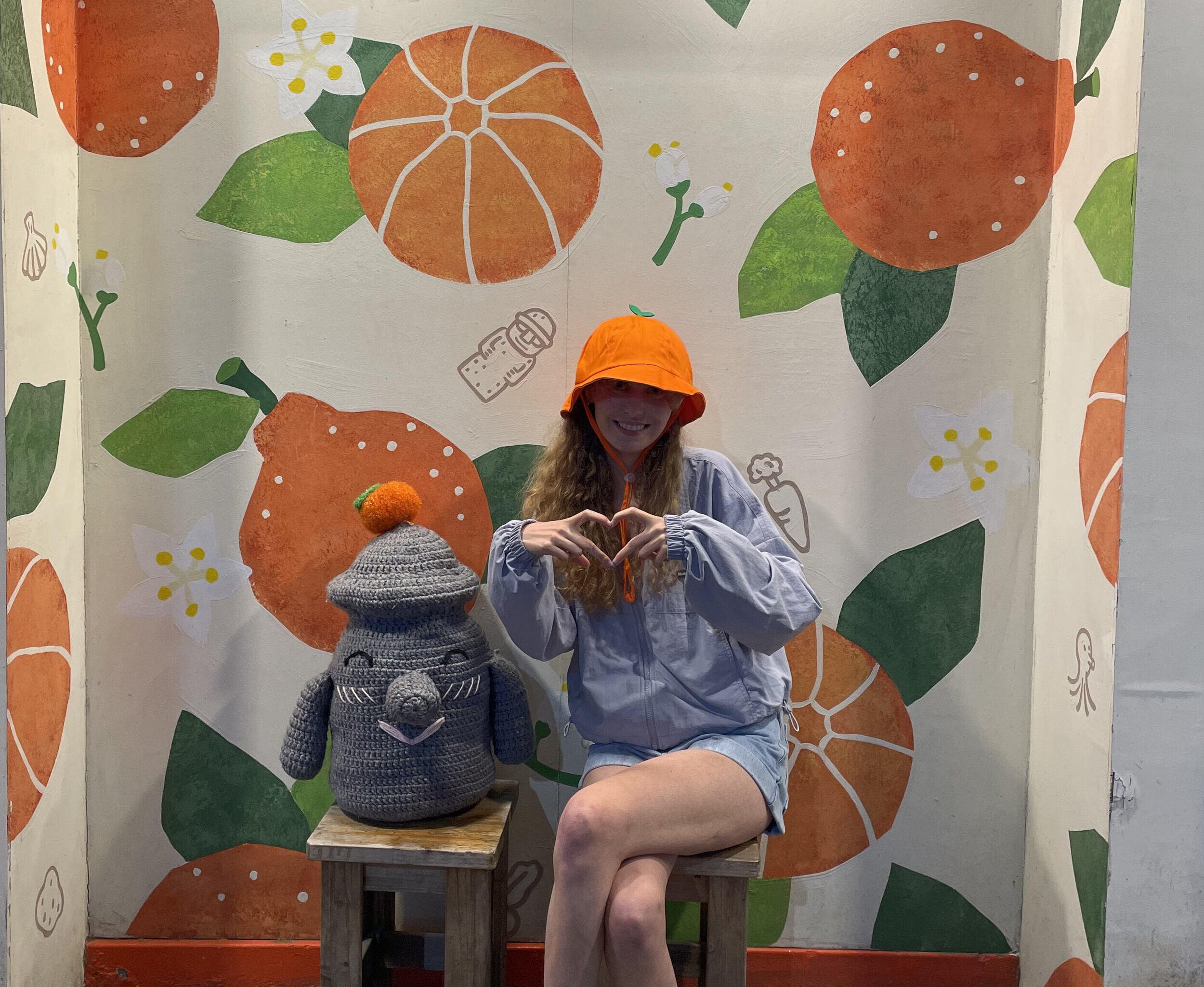 Emma Johnson sitting on a bench, making a heart shape with her hands.