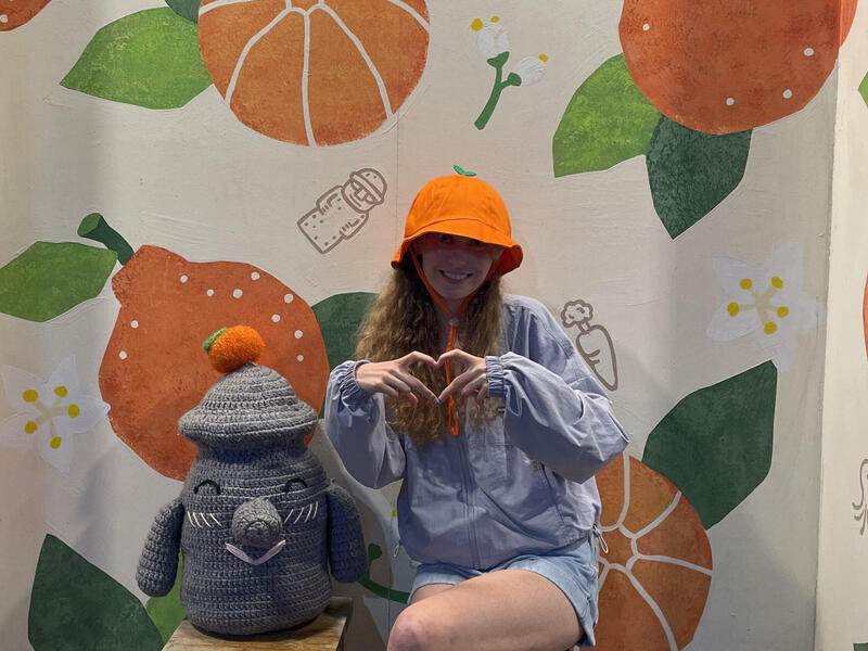 Emma Johnson sitting on a bench, making a heart shape with her hands.