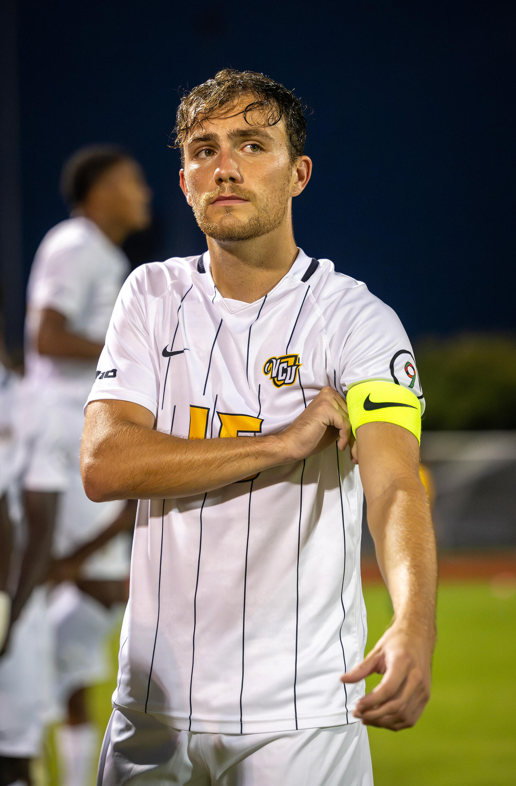 A photo of a man from the waist up. He is wearing a soccer uniform. 