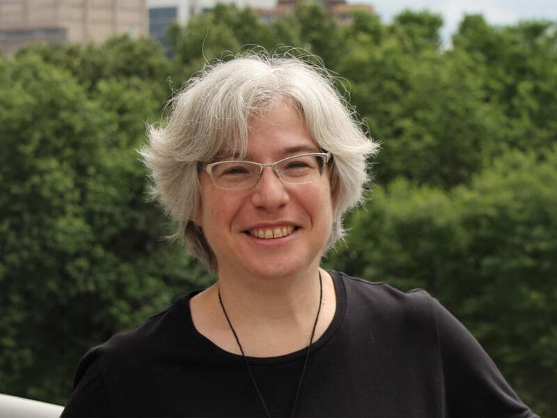 A photo of a woman wearing glasses from the shoulders up. 