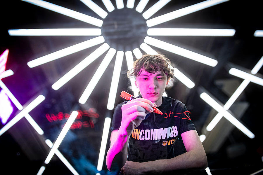 A photo of a person writing out a math equasion with an orange marker. 