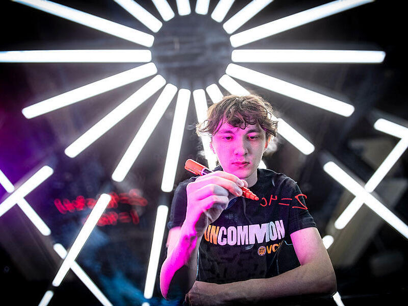 A photo of a person writing out a math equasion with an orange marker. 