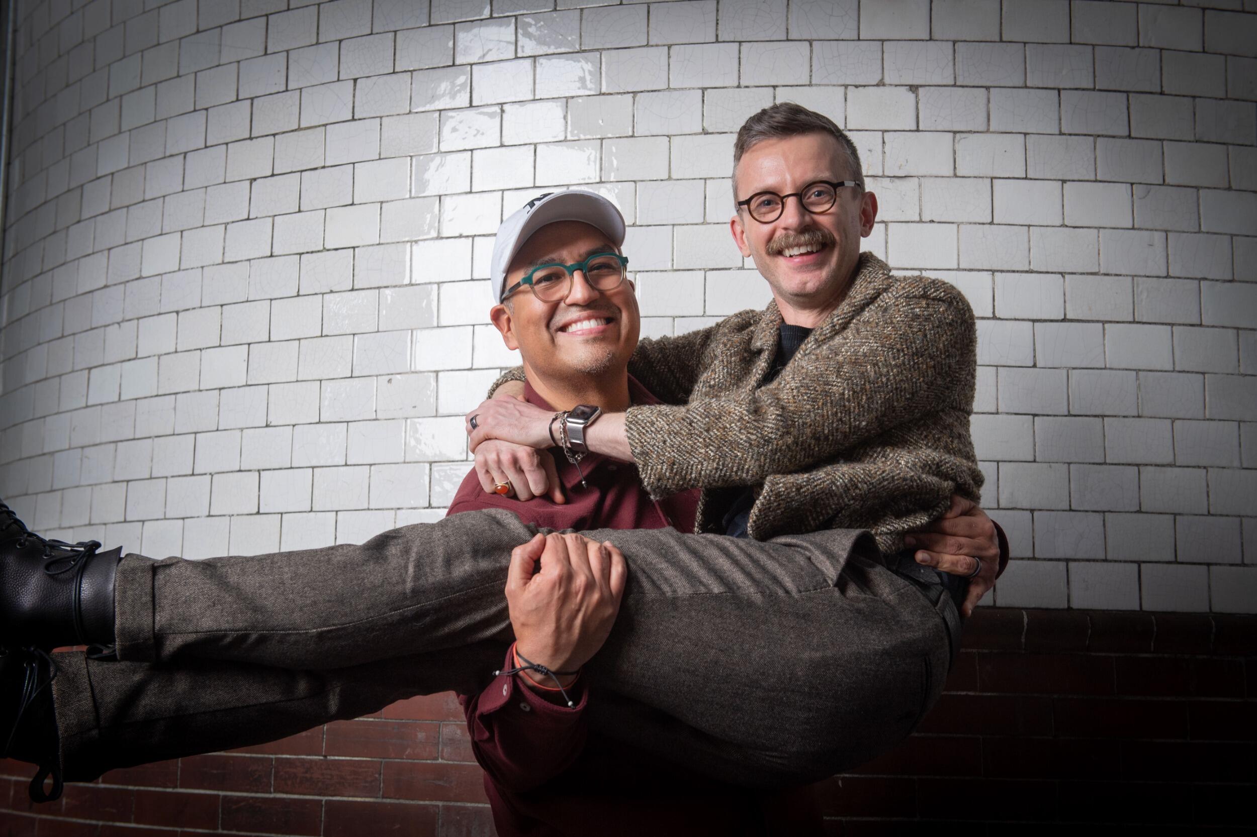 A photo of a man holding another man in his arms. 