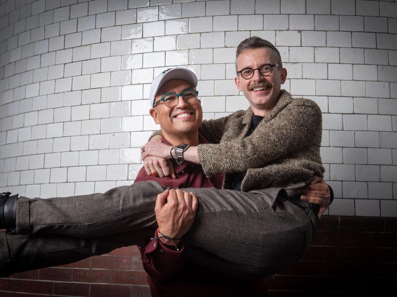 A photo of a man holding another man in his arms. 