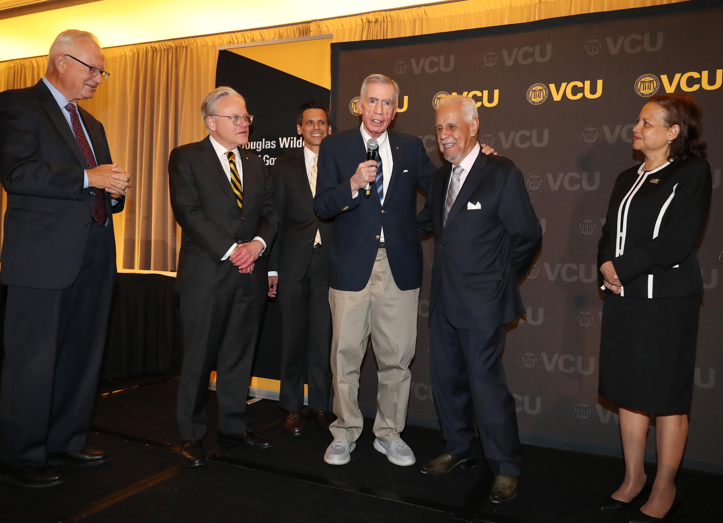 Four men and one woman standing in around each other. 