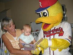 Held by her grandmother Wanda Clark, 10-month old Haley Hutchins, from Lunenburg County, gets two surprises -- a new “Garfield Color Me Fun” book and a visit from baseball’s Diamond Duck. The visit came on Haley’s discharge day, after spending five days at the VCU Children’s Medical Center.

Photo by Michael Ford, University News Services