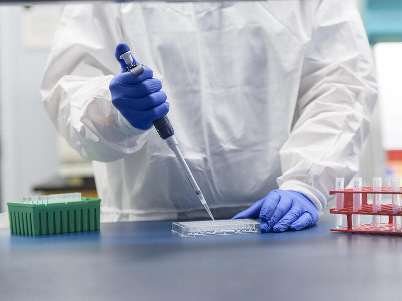 A School of Pharmacy researcher distributes liquids into a dish