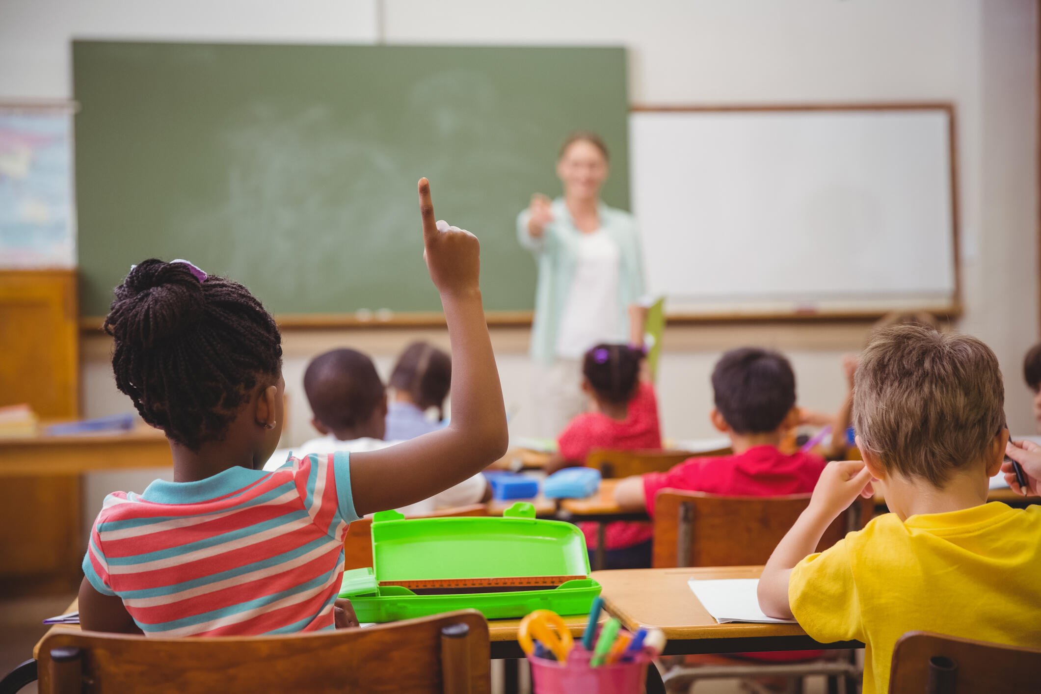 A teacher acknowledges a student who has raised their hand in class.
