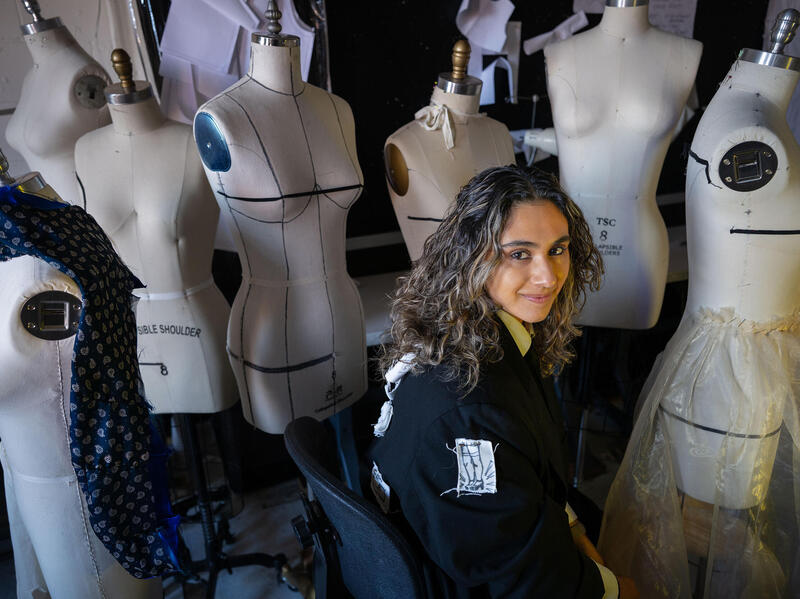 A photo of a woman sewing at a table. 