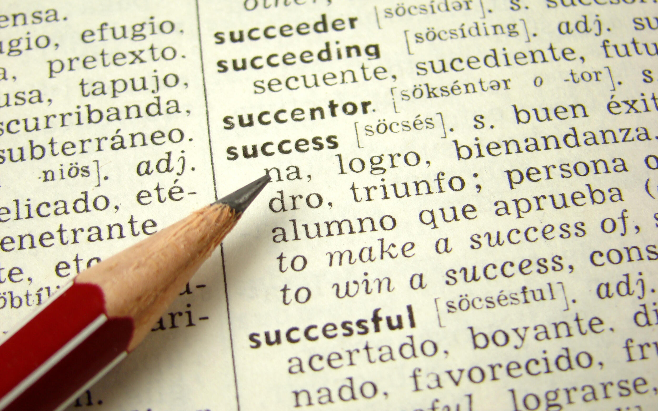 A ohoto of a pencil resting on a dictionary page with the terms \"succeeder,\" \"succeeding,\" succesntor,\" \"success\" and \"successful\" on it. 