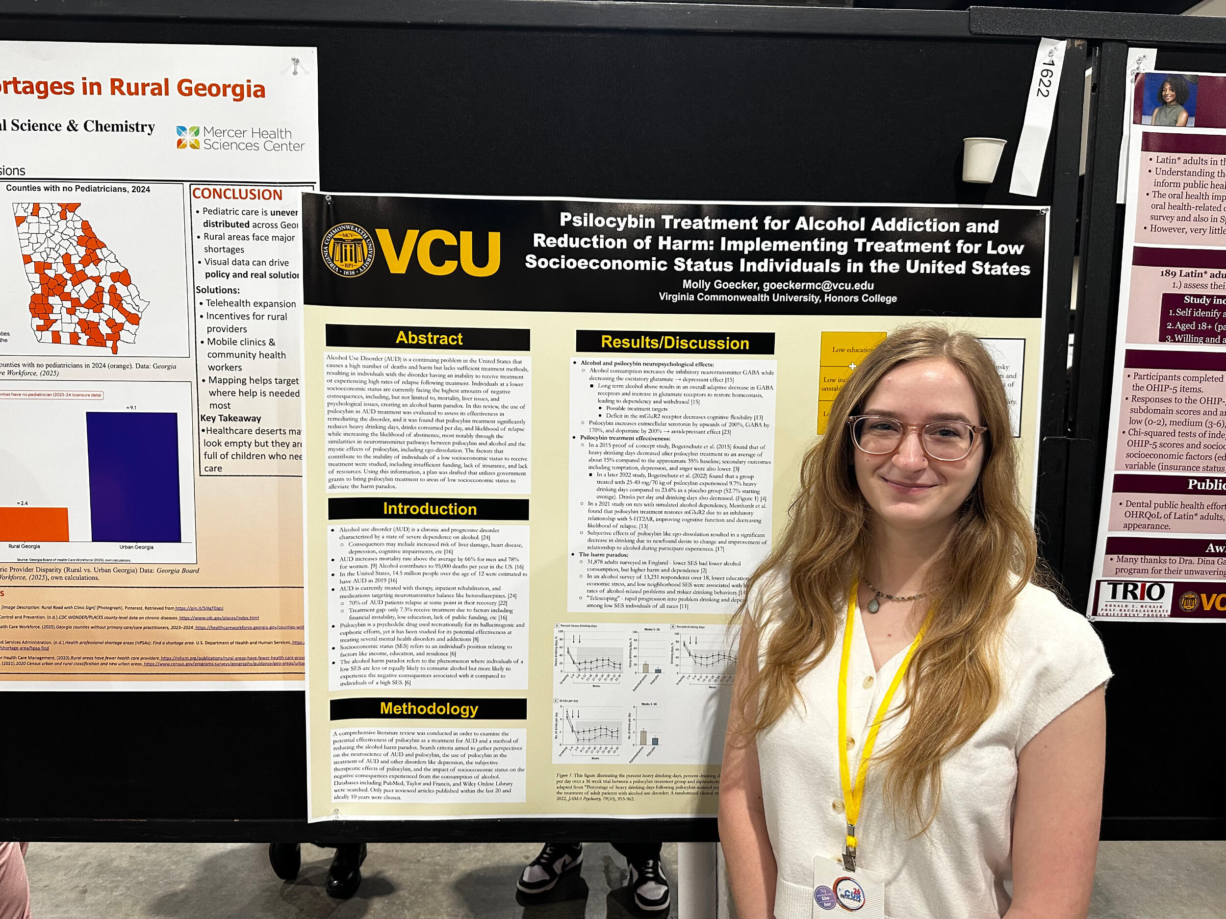 A woman stands in front of a research poster board.