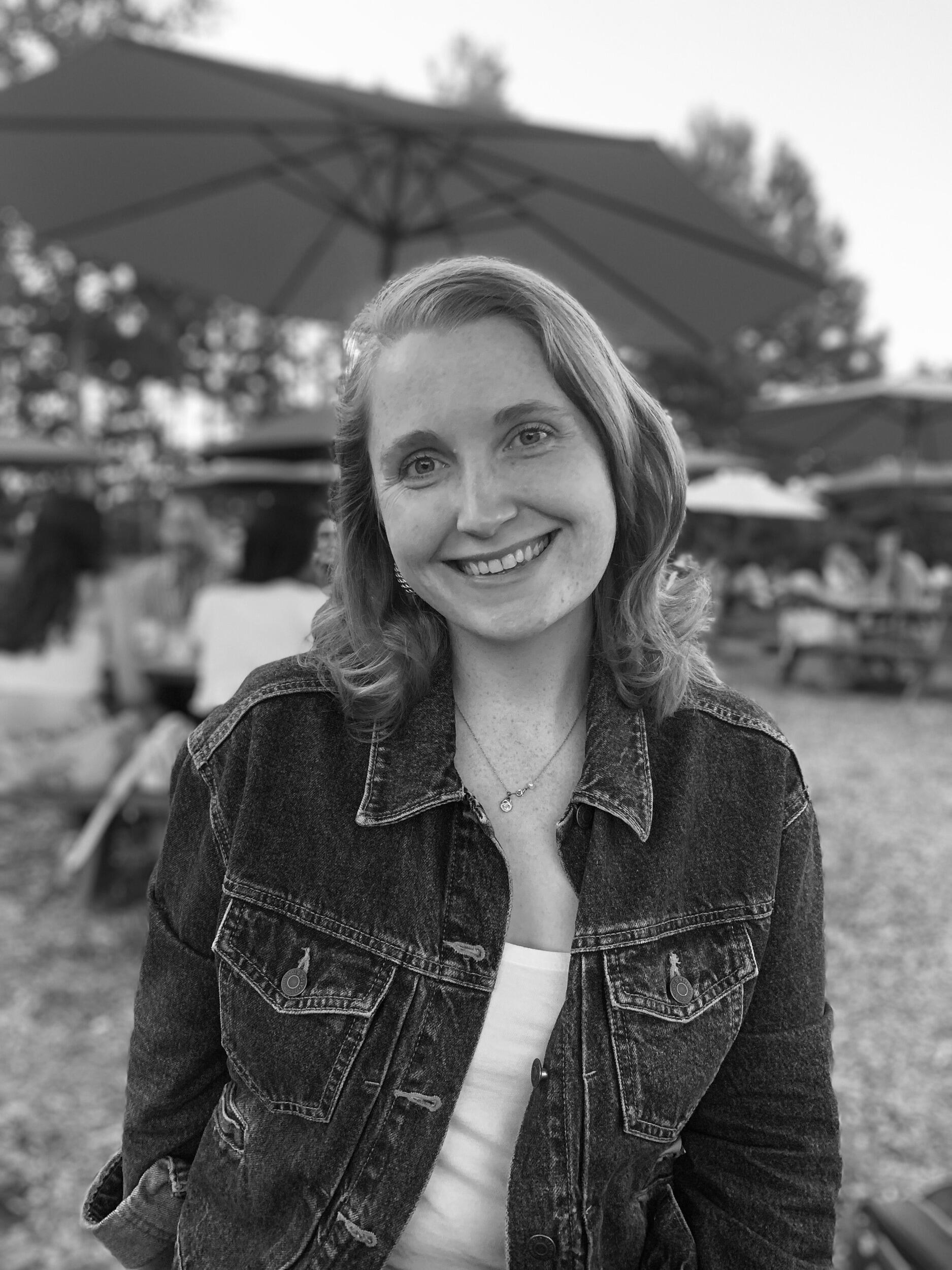 A smiling woman outside.