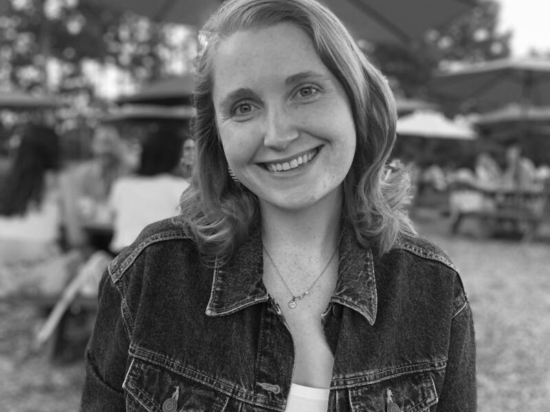 A smiling woman outside.