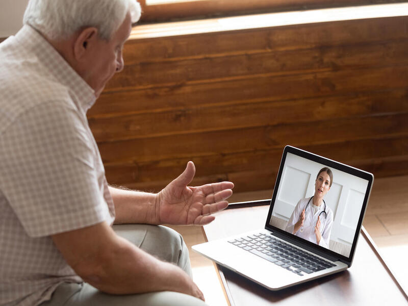 A doctor speaks to a patient via videoconference.