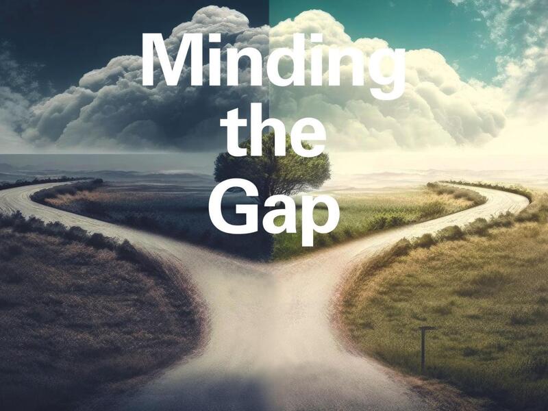 A picture of a road going around a tree that says \"Minding the Gap\" in white letter overtop of it. 