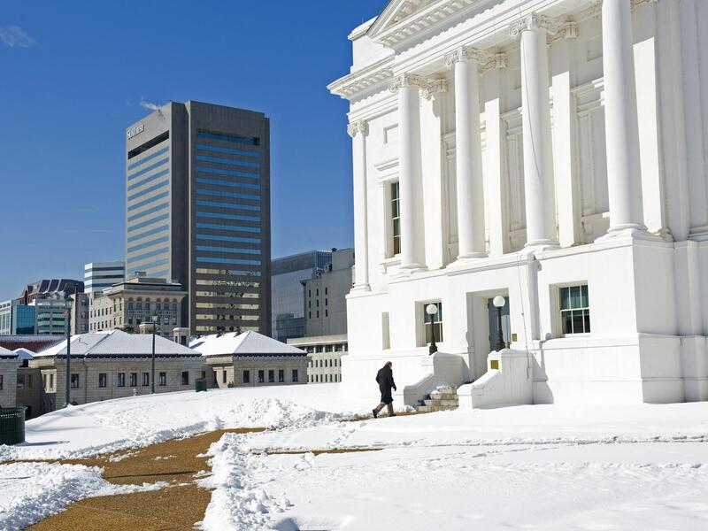A person walking up to the Virginia State Capitol in the snow. 