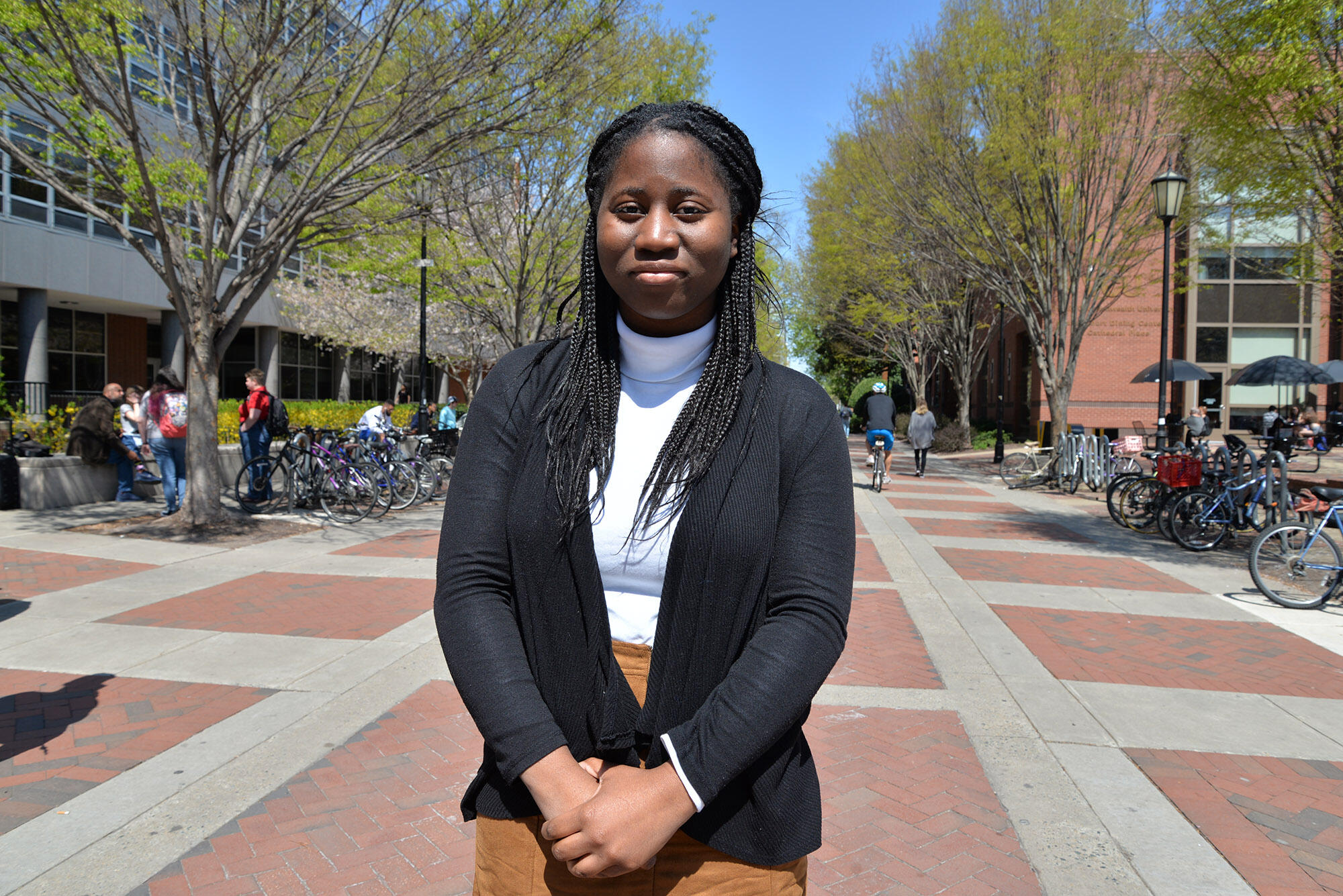 Woman standing in front of brick walkway.