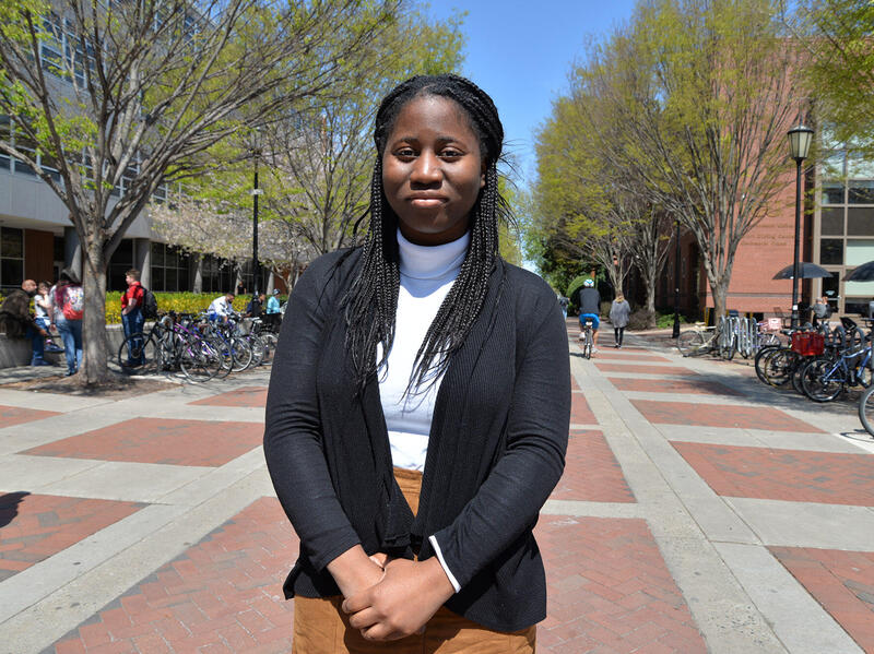 Woman standing in front of brick walkway.