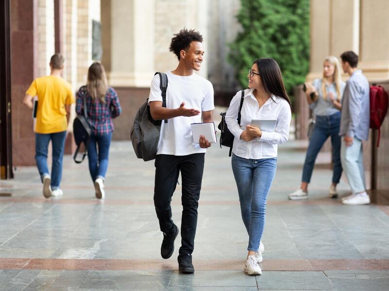 Two students in conversation while walking.