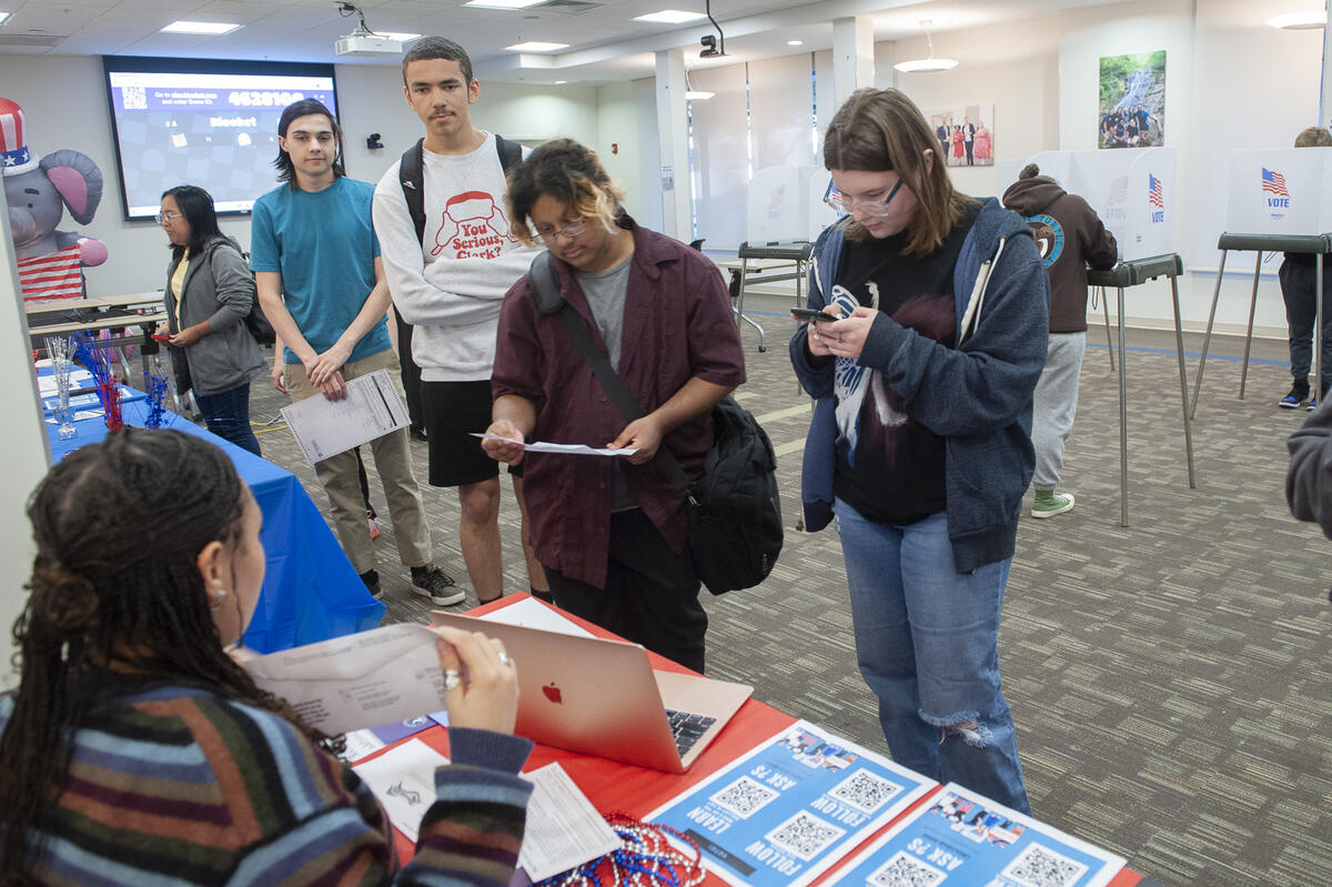 A photo of people standing in line at a polling place. 