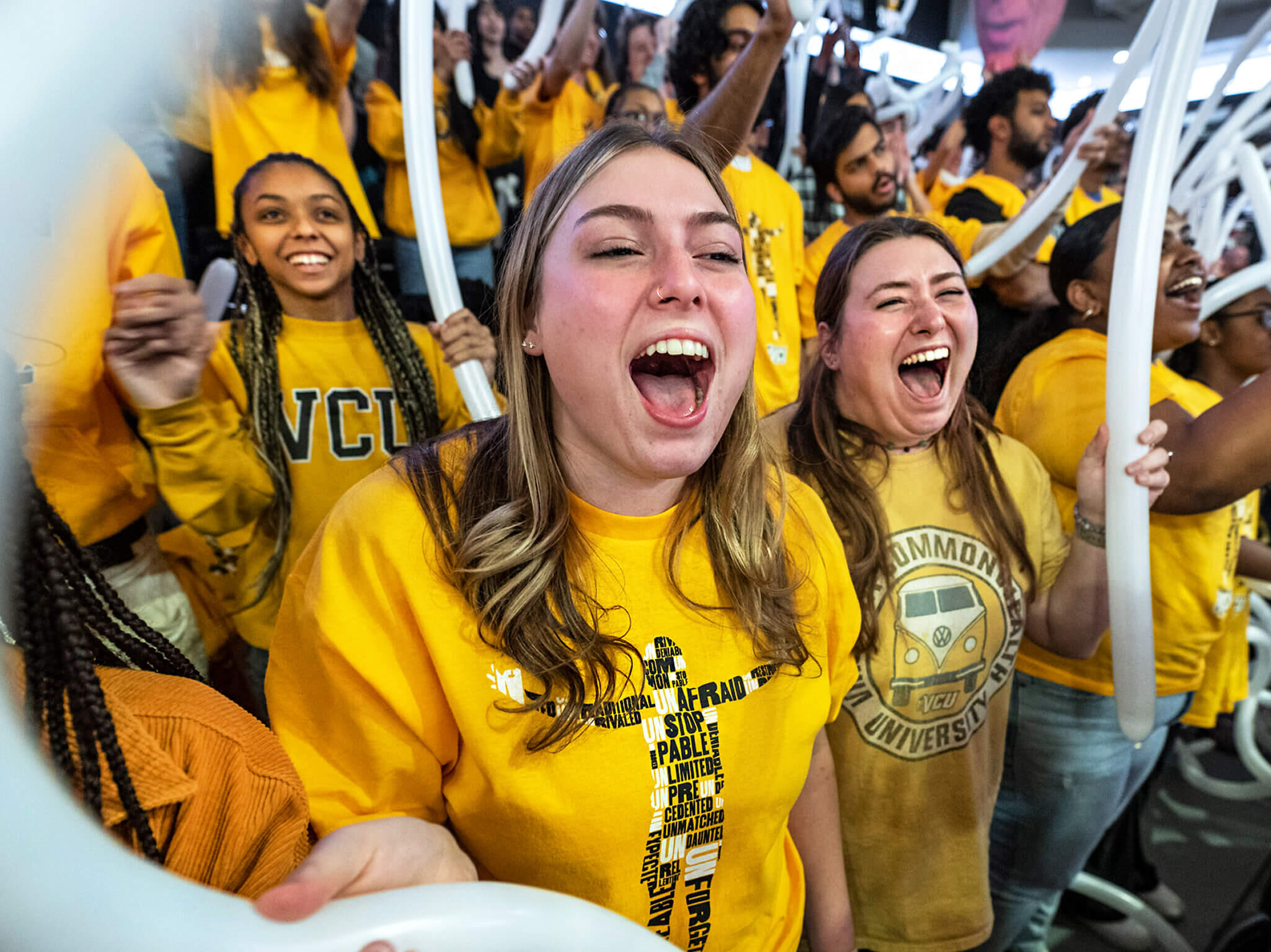 A photo of a crowd of people wearing VCU t-shirts and cheering 