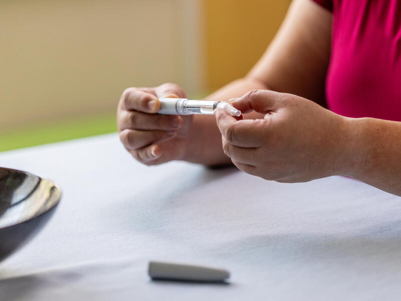 A person holds a GLP-1 injection device.