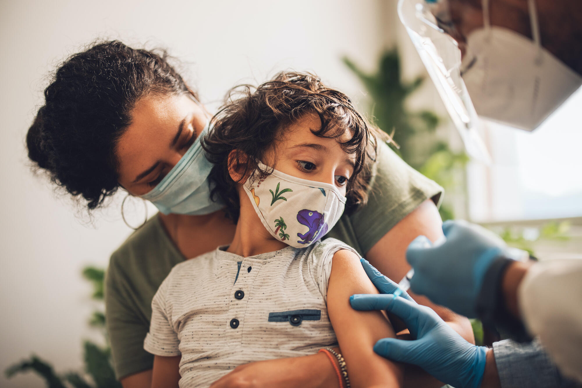 A young child receives a vaccine shot
