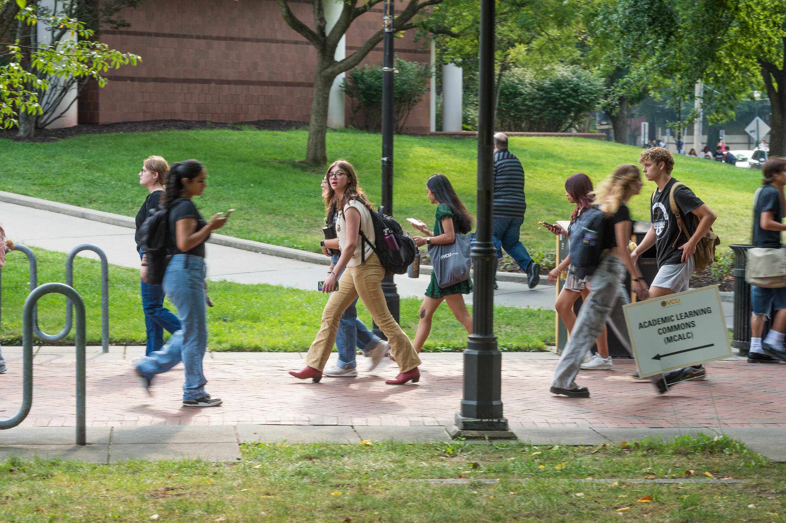 A photo of people walking across the sidewalk. 