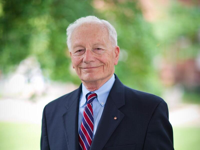 A photo of a man wearing a suit standing outsid.e 