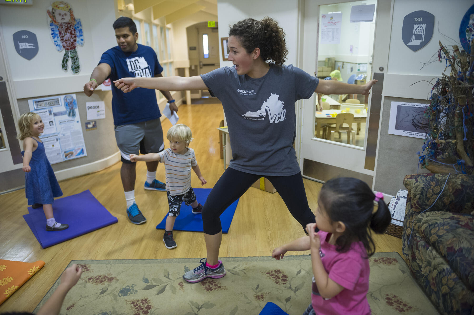 Zachary Pottanat and Tori Rodgers, co-presidents of the Pediatrics Interest Group, show the children a pose.