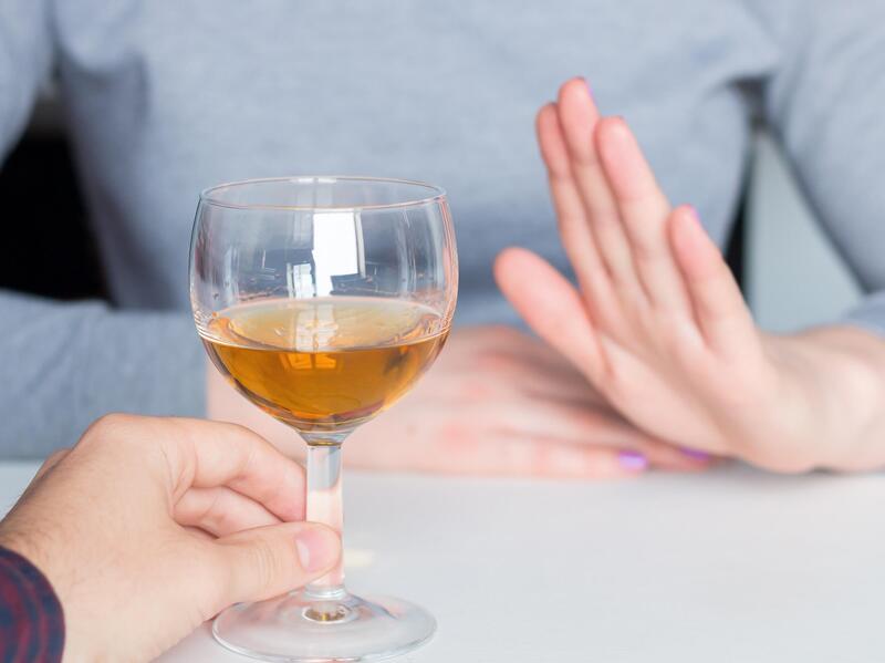 A raised hand to an offered glass of wine implies the refusal of the drink.