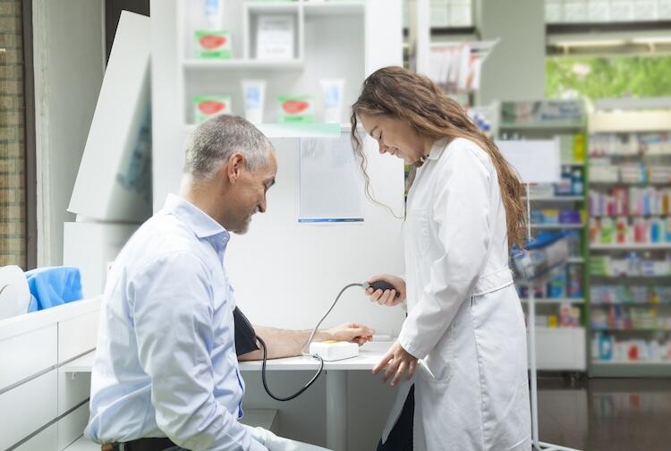 A photo of a doctor taking a patient's blood pressure. 