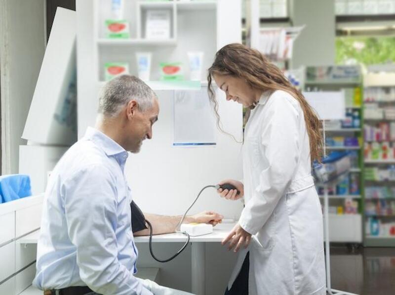 A photo of a doctor taking a patient's blood pressure. 
