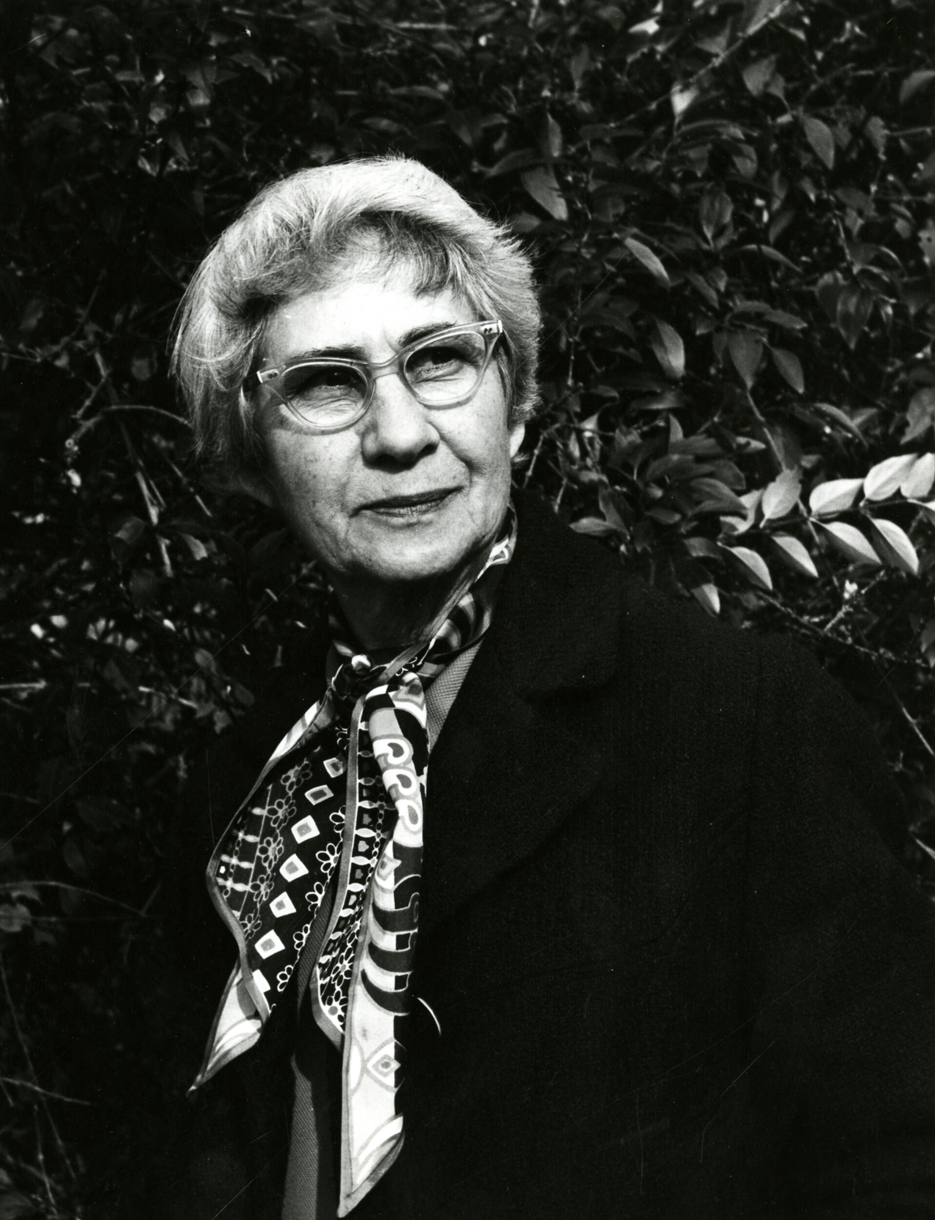 A black and white photo of a woman from the chest up. 