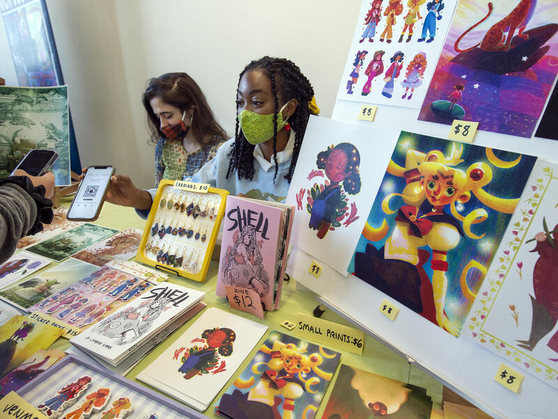 VCU graduates Camryn Simms (right) and Lillian Trenton display and sell their artwork at the Richmond Indie Comic Expo.