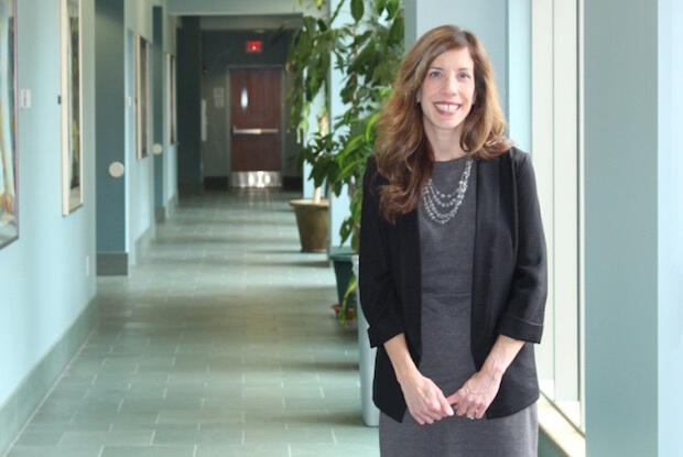 Tracye Proffitt stands in a building hallway.