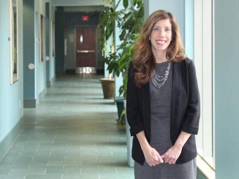 Tracye Proffitt stands in a building hallway.