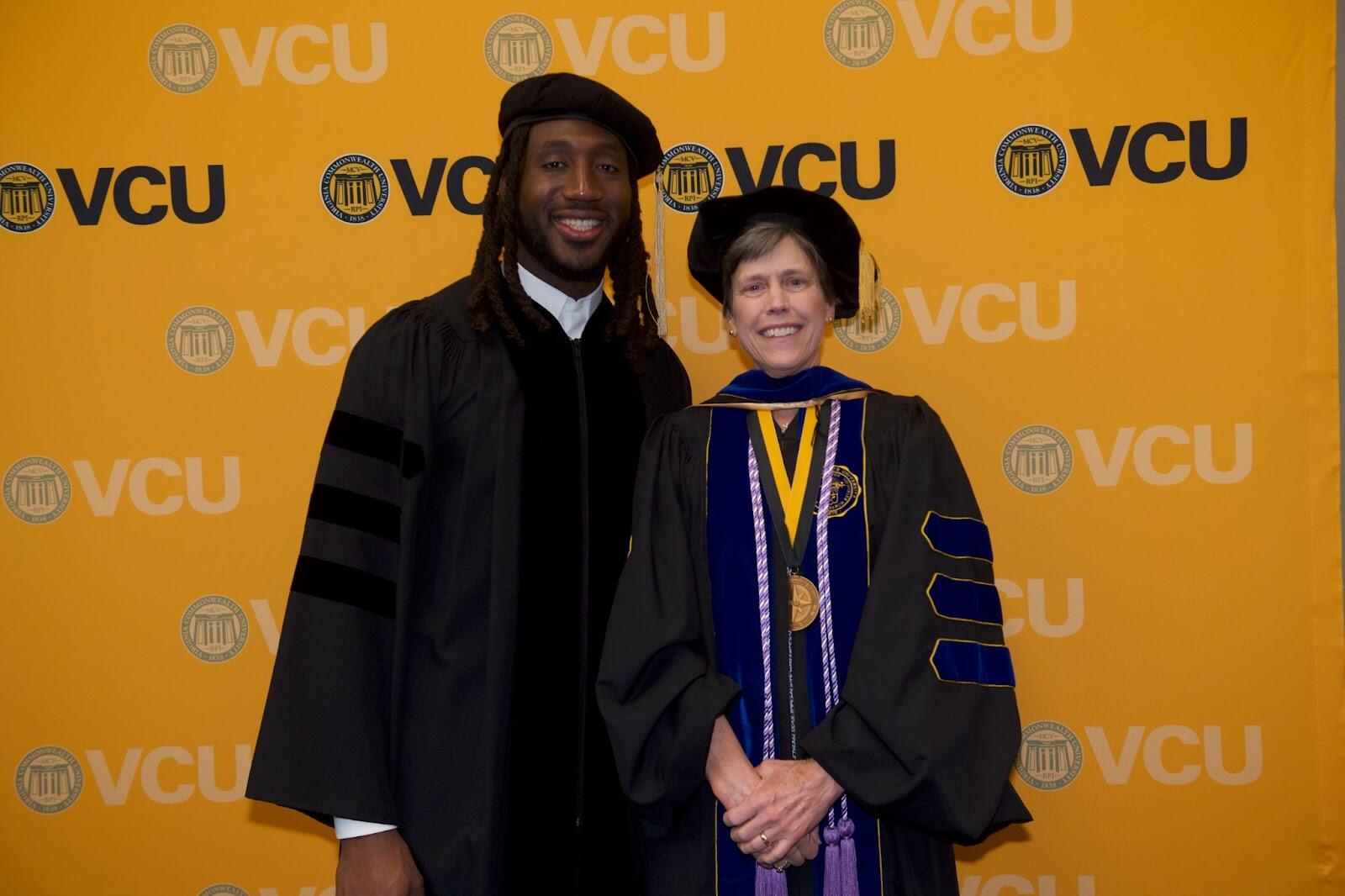 A photo of a man and woman standing next to each other in graduation gear. 