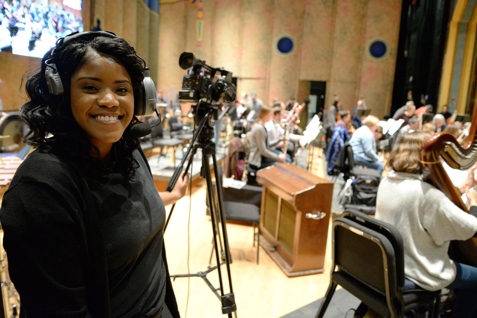 Erica Mokun, a junior broadcast journalism major, takes a break from operating a video camera during a rehearsal of the Richmond Symphony.