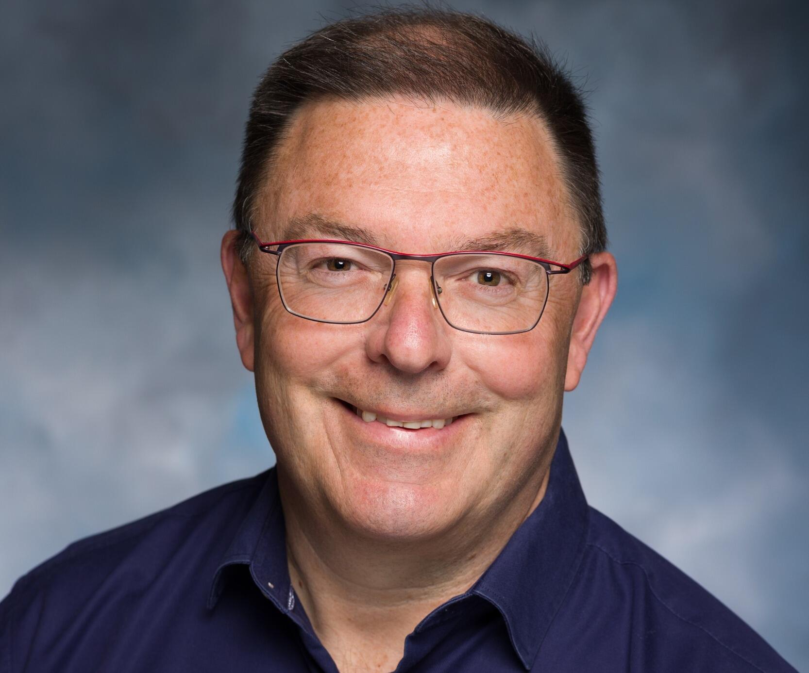 A photo of a man from the shoulders up. 