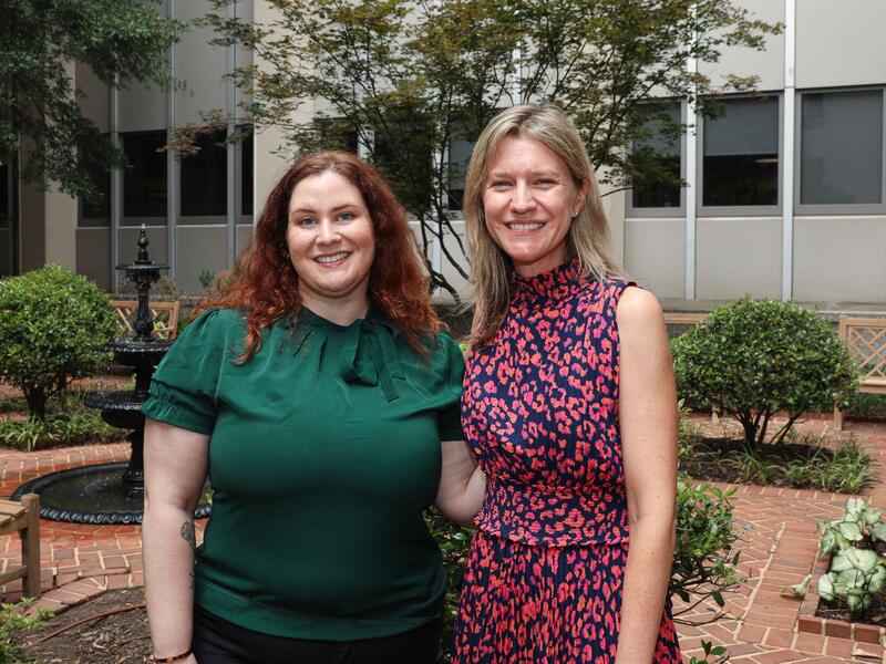 A photo of two women standing outside. 
