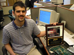 Jonathan Andrews holds his award in the VCU School of Engineering lab where it was designed. A prototype of his circuit board design is in front of his plaque.

Photo by Mike Frontiero, University News Services