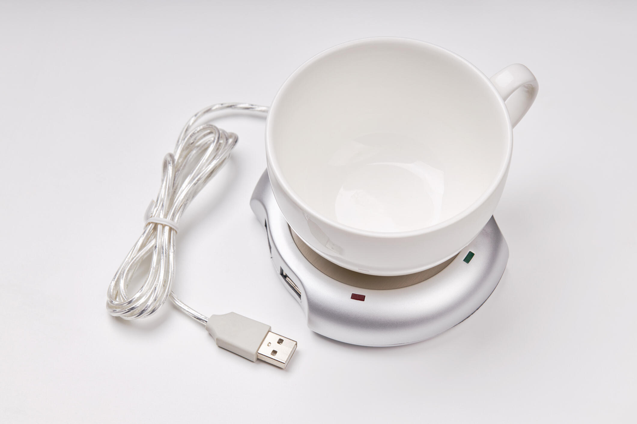 A picture of a white mug on a mug warmer. 