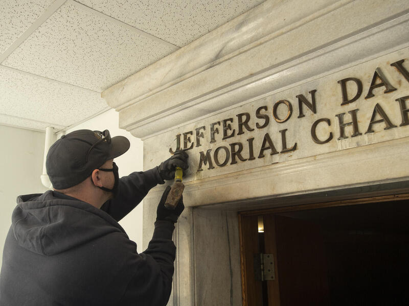 A V C U worker removes letters from the Jefferson Davis Memorial Chapel in the West Hospital.