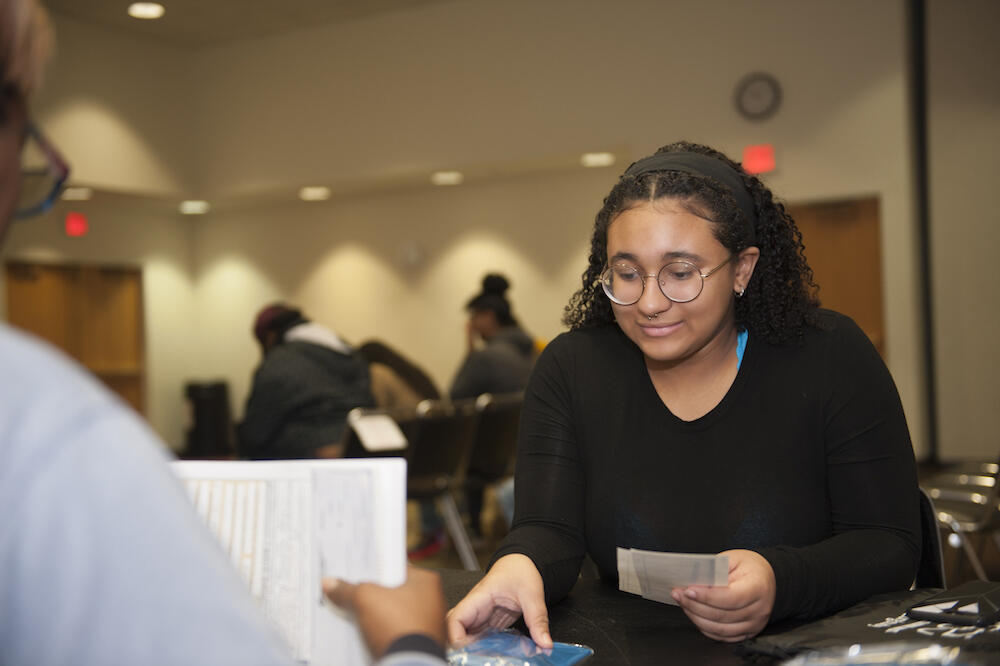 Kymberly Hall receives her passport at the Passport Caravan event.  (Photo by Tom Kojcsich, University Marketing)