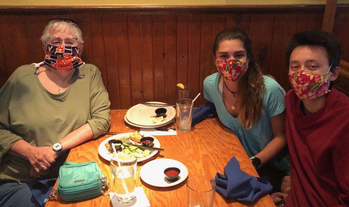 People at restaurant table wearing masks. 